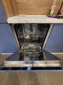 a dishwasher with its door open on a counter at Master apartman in Podgorica
