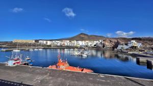 an orange boat is docked in a harbor at La Abundancia in La Restinga