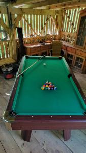 a green pool table with a pile of balls on it at Gozdna koča Studeno in Kočevje