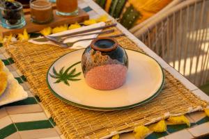 a vase sitting on a plate on a table at Riad JAIA in Marrakesh