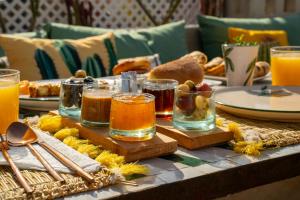 a table topped with glasses of orange juice and bread at Riad JAIA in Marrakesh +43 photos