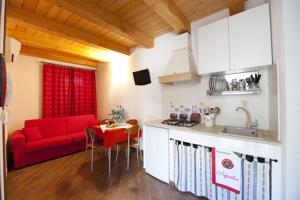 a kitchen and a living room with a red couch at Le Case Dello Zodiaco albergo diffuso in Modica