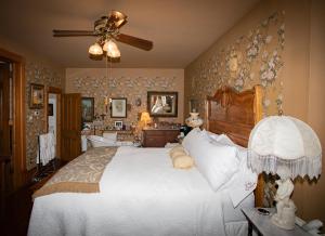 a bedroom with a bed and a ceiling fan at The Queen, A Victorian Bed & Breakfast in Bellefonte +150 photos