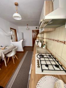 a kitchen with a stove top oven next to a table at Cozy Apartment D&D in Topliţa