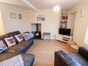 a living room with a couch and a fire place at Cobbler's Cottage in Norwich