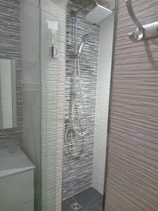 a shower with a glass door in a bathroom at Waterfront apartment in Aghroud in Ti nʼ Mansour +4 photos