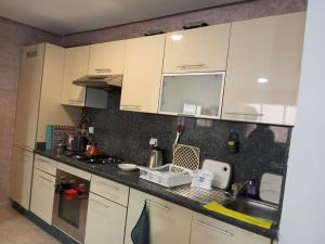 a kitchen with white cabinets and a sink at Waterfront apartment in Aghroud in Ti nʼ Mansour