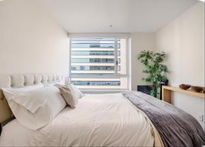 a bedroom with a large white bed with a window at Polanco condo, alberca y Gym in Mexico City