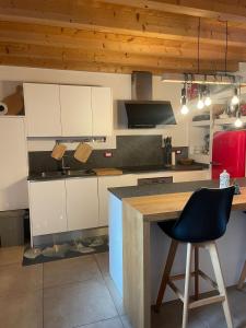 a kitchen with white cabinets and a bar with a chair at Casa Riva Us in Dussoi