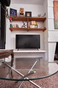a living room with a flat screen tv on a wall at Rio Holístico Escapada de Bienestar y relax para Parejas o duplas in Ramallo