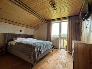 a bedroom with a bed and a large window at Jenta in Kyiv
