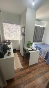 a bedroom with a bed and a desk and a table at KIT 300- com Ar cond - 5 min do aeroporto, rodoviária e embaixadas in Brasília