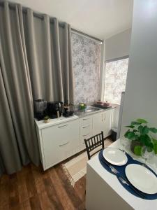 a kitchen with a table and a table and a dining room at KIT 300- com Ar cond - 5 min do aeroporto, rodoviária e embaixadas in Brasília