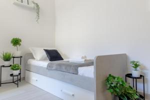 a bed in a white room with plants at Tropical Boutique Apartment in Gallipoli +44 photos