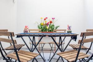 a table with chairs and flowers on it at Tropical Boutique Apartment in Gallipoli