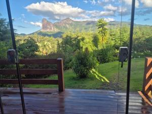 a bench in front of a window with a mountain view at Pedra Azul Chalé Clássico in Domingos Martins