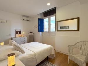 a bedroom with a bed and a dresser and a window at Pensão Destino in Castelo de Vide