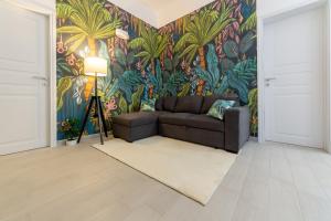 a living room with a couch and a tropical wallpaper at Tropical Boutique Apartment in Gallipoli