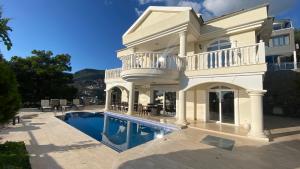 a large white house with a swimming pool at Villa royal in Alanya