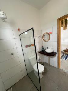 a bathroom with a toilet and a sink at Vila Pimenta Rosa in Caraíva +9 photos