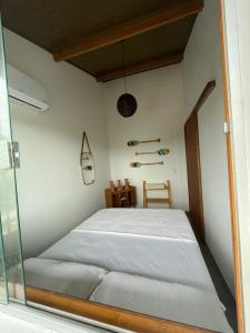 a bed in a room with a glass window at Vila Pimenta Rosa in Caraíva
