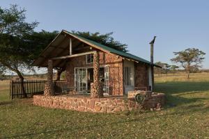 a small stone house sitting in a field at Bateleur Nature Reserve & Stamvrug Hiking Trails in Modimolle