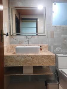 a bathroom with a sink and a mirror at Casa - 1 Suíte e 2 Quartos in Saquarema +6 photos