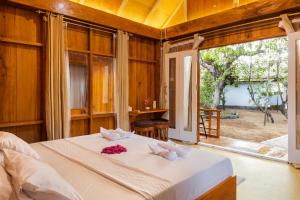 a bedroom with a bed and a large window at joe Dive resort in Pulau Lembeh +11 photos