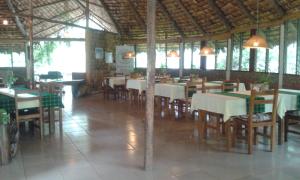 a restaurant with tables and chairs in a building at Meru Mbega Lodge in Usa River
