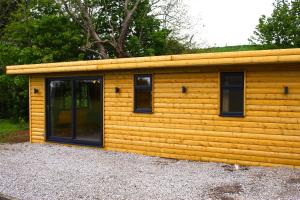 a wooden cabin with windows on a building at Paull Holme Farm Bed and Breakfast in Paull