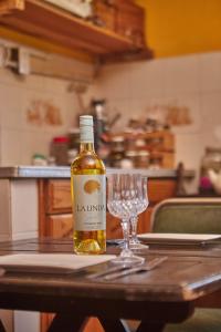 a bottle of wine and a wine glass on a table at Rio Holístico Escapada de Bienestar y relax para Parejas o duplas in Ramallo +23 photos