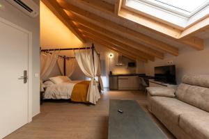 a bedroom with a bed and a couch at Alojamientos La Antigua in Molina de Aragón