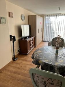 a living room with a table and a television at Studio pour 2 personnes à Tonnay Charente in Tonnay-Charente
