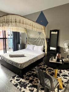 a bedroom with a canopy bed and a table at Icon Hotel in Kampala