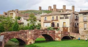 a bridge over a river in a city with buildings at Alojamientos La Antigua in Molina de Aragón