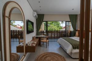 ein Schlafzimmer mit einem Bett, einem Spiegel und einem Tisch in der Unterkunft Be Caju Hotel in Barra Grande + 72 Fotos