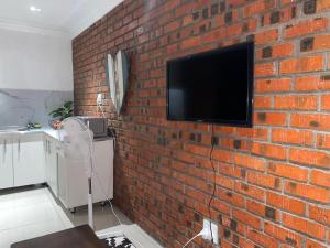 a brick wall with a tv on a brick wall at Kubbe Comfort Corner in Bloemfontein