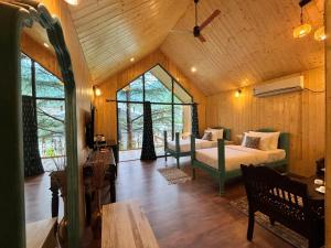 ein Schlafzimmer mit einem Bett in einem Zimmer mit Fenstern in der Unterkunft Celestial Dream in Uttarkāshi