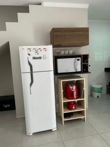 a kitchen with a white refrigerator and a microwave at CASA ESPAÇOSA e CONFORTÁVEL EM PARATY in Paraty
