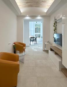 a living room with chairs and a tv and a table at ABETI'S HOUSE in Rome