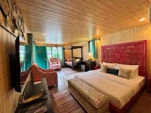 ein Schlafzimmer mit einem großen Bett und ein Wohnzimmer in der Unterkunft Celestial Dream in Uttarkāshi