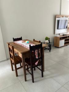 a dining room table with two chairs and a television at CASA ESPAÇOSA e CONFORTÁVEL EM PARATY in Paraty