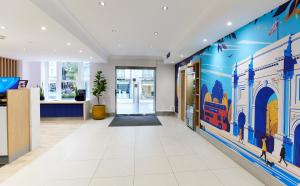 an office corridor with blue and white walls and a lobby at Thistle London Park Lane in London
