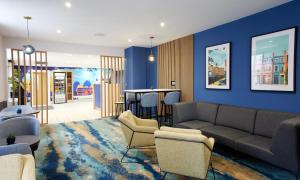 a living room with a couch and a table at Thistle London Park Lane in London +19 photos