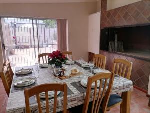 a dining room table with chairs and a large window at Mimosa House Twin Room in Brackenfell