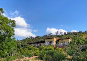 a house on top of a hill with trees at Bateleur Nature Reserve & Stamvrug Hiking Trails in Modimolle