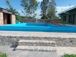 a large blue swimming pool with a stone wall at Lozano Casa de Campo in Lozano