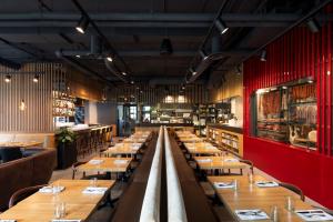 a restaurant with wooden tables and red walls at Alt Hotel Calgary University District in Calgary