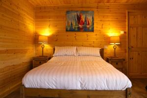 a bed in a wooden room with two lamps at Paull Holme Farm Bed and Breakfast in Paull