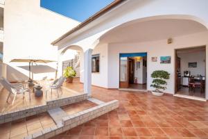 an indoor patio with chairs and a table with an umbrella at Le Chele - A Due Passi dal Mare in Torre Lapillo +69 photos